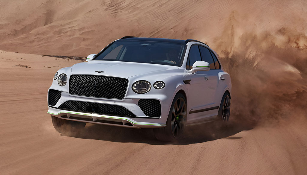 A sleek, dark green Bentley Flying Spur in motion.